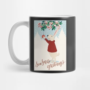 Cute rabbit in red sweater hanging up Christmas decorations in a snowy winter landscape Mug